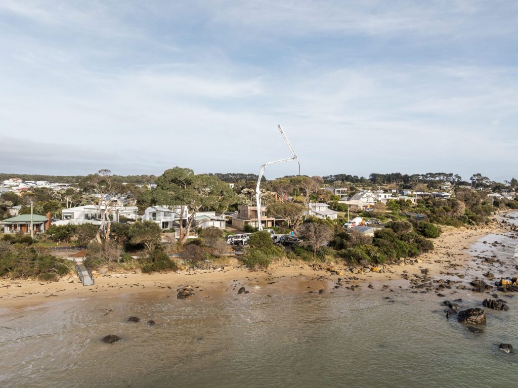 Regor boom pump reaching over the Hawley foreshore for a pathway pour